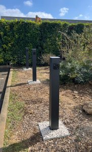 Fourniture et pose de 3 bornes EV One chez un professionnel. Installation réalisée fixés au sol, avec finition soignée sur gravier blanc.